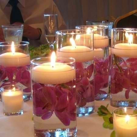 Наливаем в стакан воды, топим там цветки, лепестки и прочую красотищу, потом пускаем на воду подходящую по диаметру свечу и... эксклюзив готов